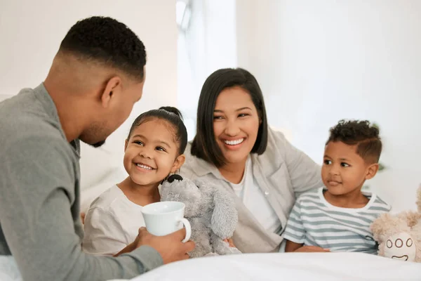 I think youre a little too young for coffee darling. a beautiful young family talking and bonding in bed together