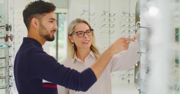 Óptica Optometrista Femenina Que Ayuda Cliente Elegir Gafas Estante Tienda — Vídeo de stock