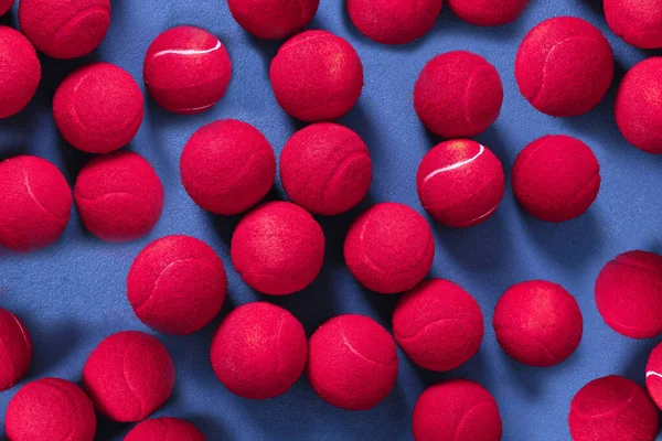 Tennis is a sport for all ages. multiple tennis balls lying on a blue tennis court