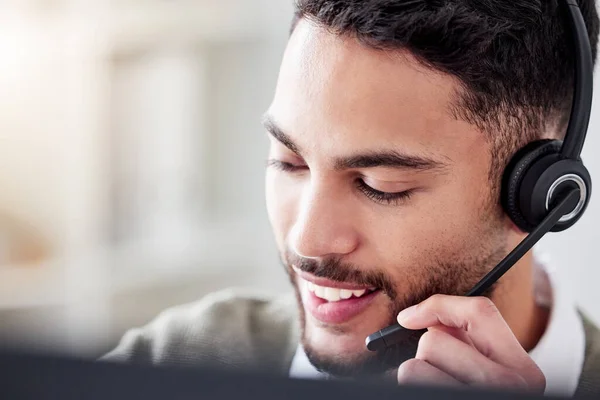 Always on call. a handsome young male call center agent working in his office