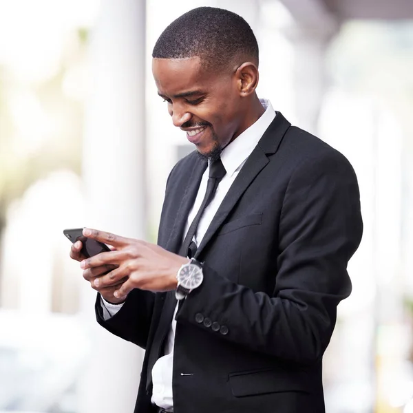 Hes a maker of big calls. a handsome young businessman checking his messages during his morning commute into work