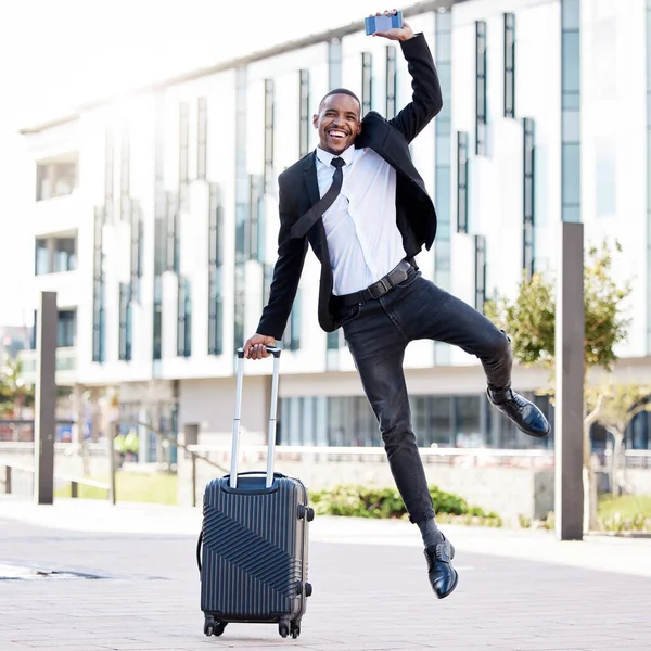 I couldnt ask for more. a young businessman jumping for joy while holding his smartphone