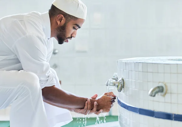 Preparations for prayer time. a young man washing his hand in a mosque