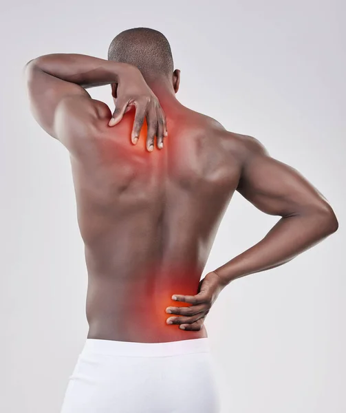 Suffer the pain of self-discipline. a man experiencing back pain against a studio background