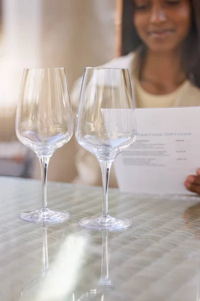 There are so many options. an unrecognisable woman sitting alone and looking at the menu during a wine tasting