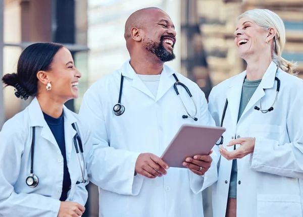 Laughter gets us through the tough times. a group of doctors using a digital tablet in the city