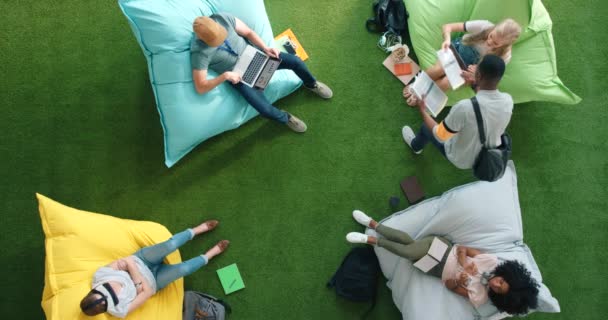Students Using Technology Sitting Bean Bags Library Bright Informal Office — Stock videók