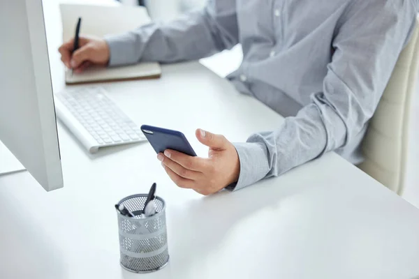 Planning is number one for every successful entrepreneur. Closeup shot of an unrecognisable businessman using a cellphone while writing notes in an office