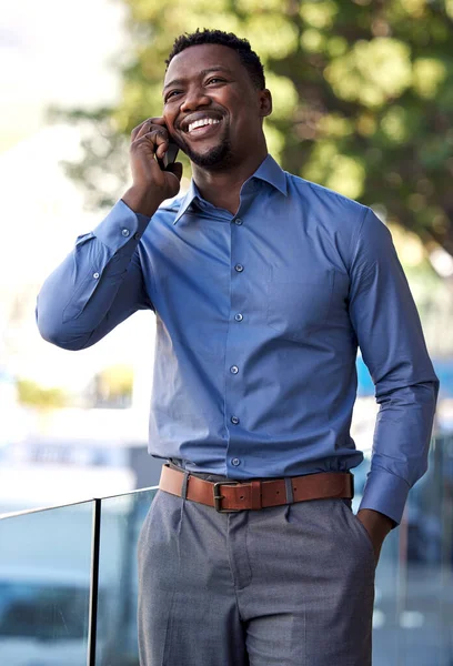 Im excited to see you. a young businessman using his smartphone to make a phone call outside