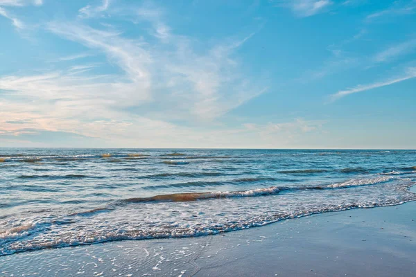 Peaceful, quiet and calm sea shore with waves on clear water against a blue horizon on a sunny day for nature copy space. Empty coastal landscape of a beautiful beach with a blue sky outside.