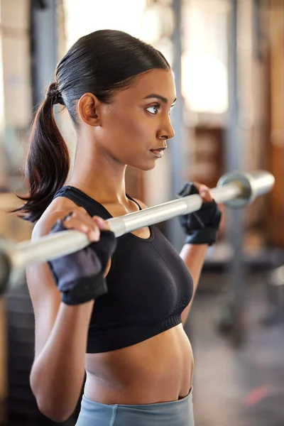 Watch me lift it like a pro. a young woman working out with weights in a gym