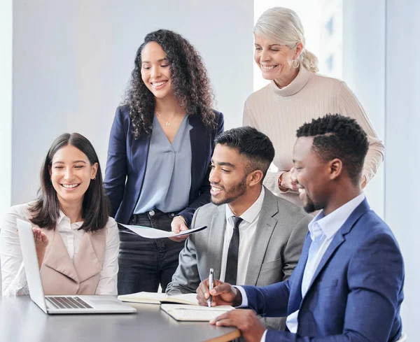 Your hard work has paid off. a group of businessepople using a laptop during a meeting