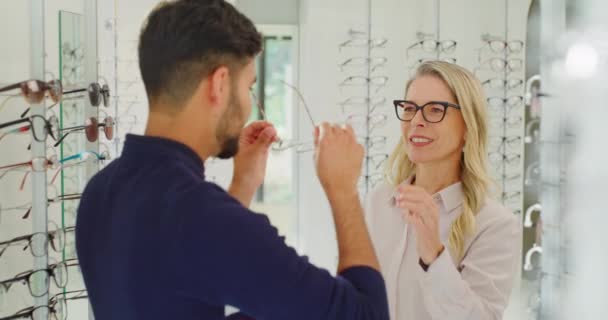 Female Optician Optometrist Assisting Customer Choose Glasses Shelf Her Shop — Vídeo de stock