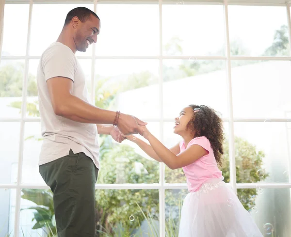Dad, dance with me. a handsome young man bonding with his daughter at home