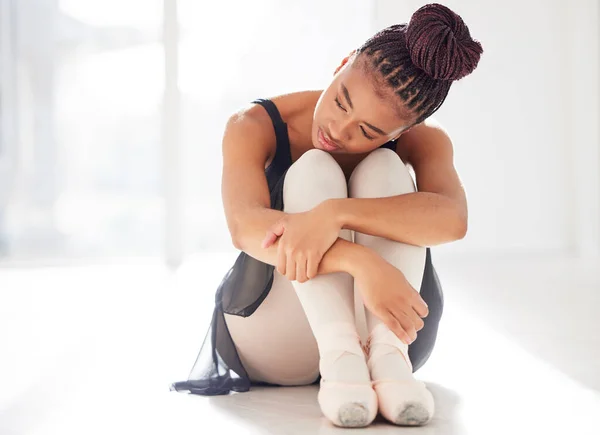 It takes time and dedication to be good at anything. a ballerina looking sad while sitting in her dance studio