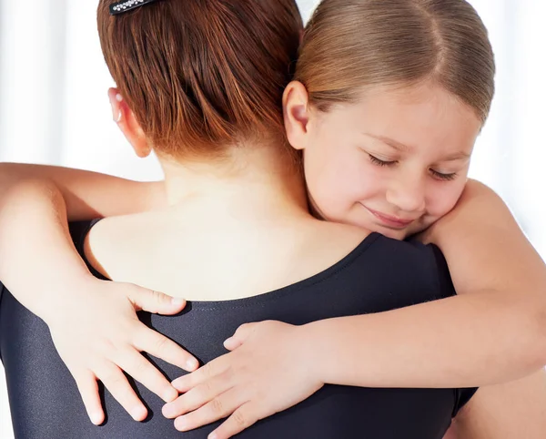 Technical perfection is insufficient. a ballet teacher hugging her student in a dance studio