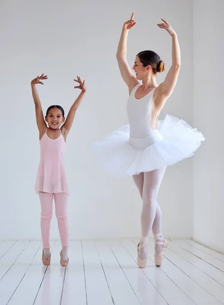 Dancing is like dreaming with your feet. a little girl practicing ballet with her teacher in a dance studio