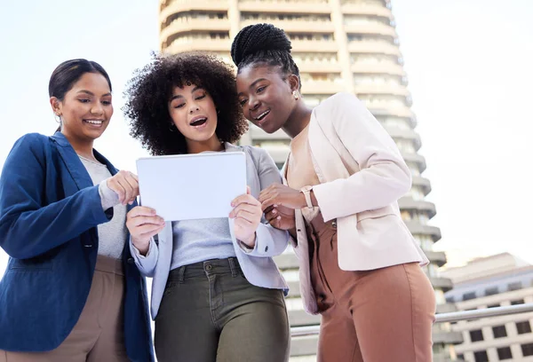 I think we have the winning idea right here. Low angle shot of a diverse group of businesswomen standing outside on the balcony and using a digital tablet
