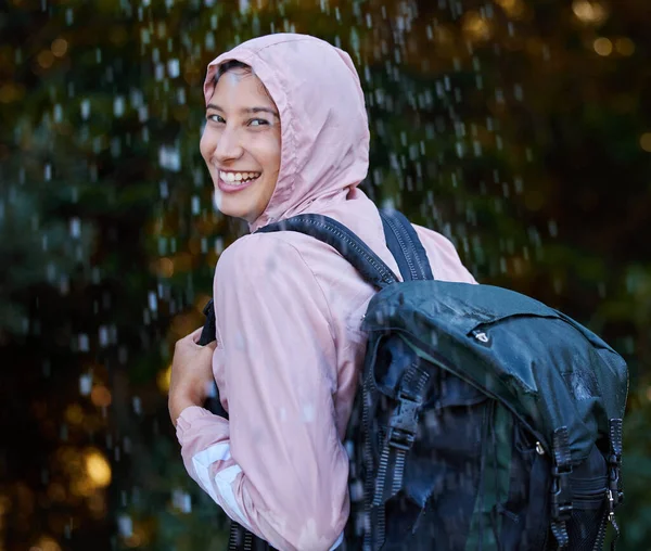 This hike isnt cancelled just because of some rain. an attractive young woman standing alone outside in the rain