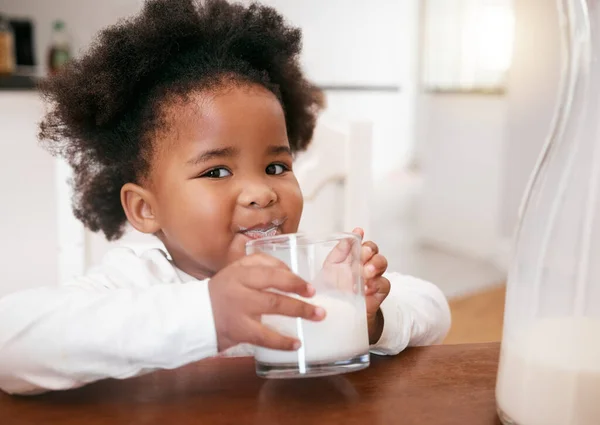 This is so my bones grow strong. a little girl enjoying a glass of milk