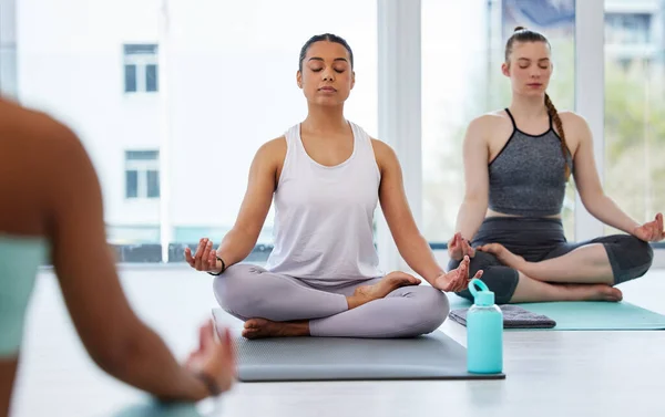 Its all in the breath. a diverse group of women sitting together in a yoga studio and meditating