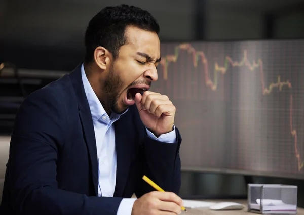 Tired businessman on the stock market, trading during a financial crisis. Yawning trader in a bear market, looking at stocks crashing. Market crash, stock default and economy failure or depression.