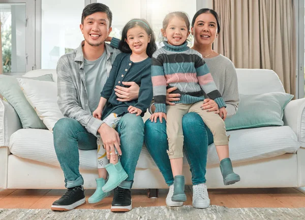 Chores does not a family day make. Portrait of a young family bonding on the sofa at home