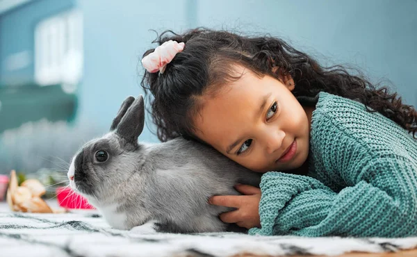 I love spending my days at home with my rabbit. an adorable little girl bonding with her pet rabbit at home