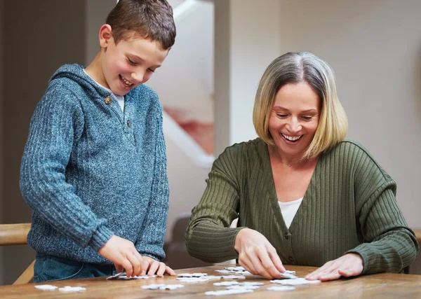 Start from the outside work your way in. a mother completing a puzzle with her son