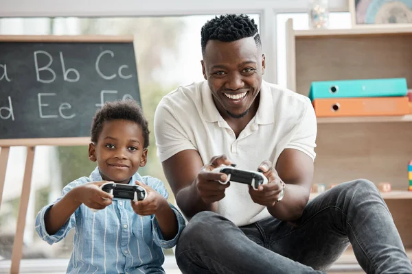 Youre way better than me at this, son. a little boy and his dad playing video games at home