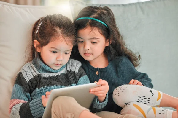 Digital Babysitter Two Young Sisters Using Digital Tablet Together Sofa — Foto Stock