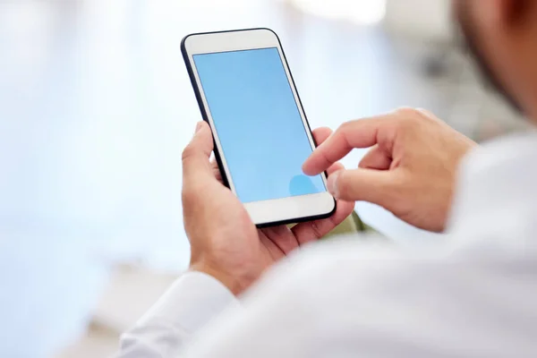 Blank blue screen of a phone with a businessman typing or scrolling the internet. Closeup of corporate or entrepreneur male texting or browsing the web for social media news and clickbait.