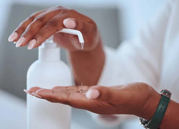 Closeup of beautiful female hands washing using hand sanitizer with care. African American lady cleaning her skin for health and wellness reasons. A woman with pretty nails using hygiene soap