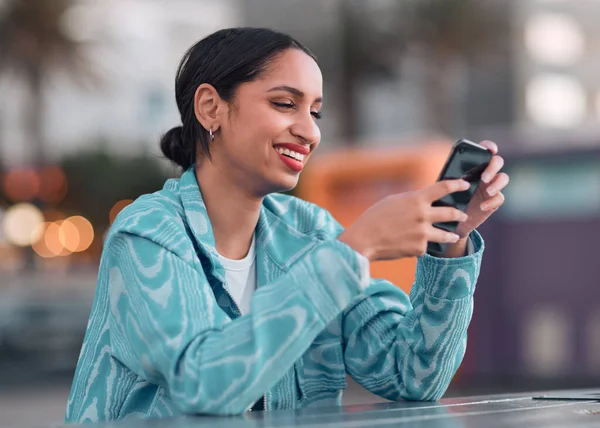 Happy woman texting on a phone, browsing social media or chatting on an instant, trendy and online chat app. Single female looking confident, reading a message on a dating website.