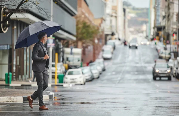 My city is beautiful on rainy days. a handsome businessman walking to work on a rainy day