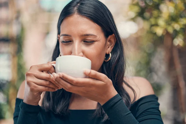 Woman relaxing holding coffee in joy outside. Peaceful, calm and stressless female sipping a mug of tea in a cafe outside. Closeup of carefree lady enjoying a hot beverage in fresh air
