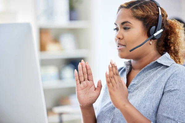 Online seminar, workshop, and meeting being had by a call center agent explaining, taking and having a conversation on a desktop computer while working in an office. Female giving customer service.