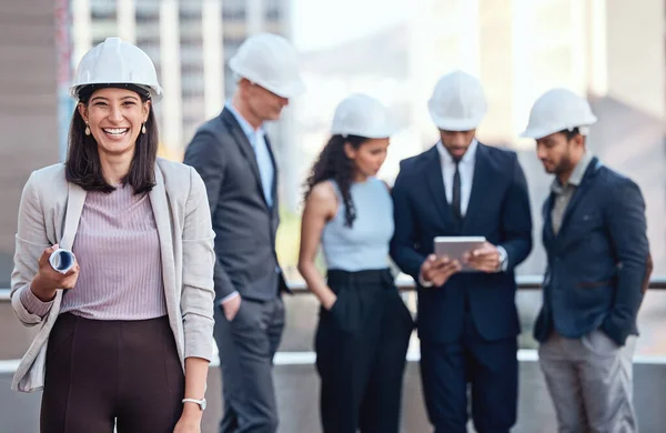 If you hire us, you can expect exceptional results. a businesswoman wearing a hardhat while standing outside with her colleagues