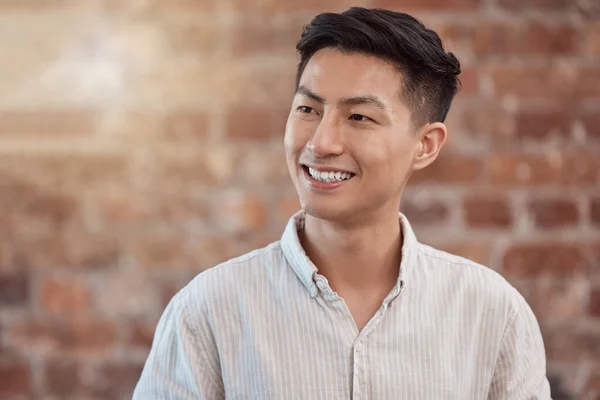 Happy, confident and smiling business man looking thoughtful while working in a creative startup agency. Cheerful, charming and positive designer feeling ambitious, optimistic and ready for work.