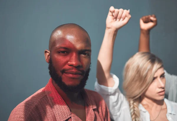 Portrait of young, african american man standing together with protesters, holding fists, showing strong striking gesture in support Social justice human rights issues movement stands in unity.