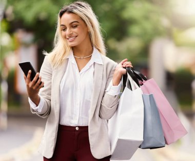 Are there any sales online. an attractive young woman texting while out shopping in the city