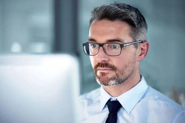 Be known for being the hardest working person in the room. a businessman using his computer while sitting at his desk