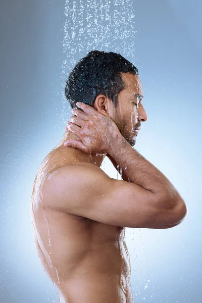 Learn to know yourself first. Studio shot of a handsome young man washing his hair in a shower against a grey background