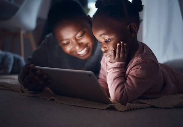 And then they lived happily ever after. a mother reading bedtime stories with her daughter on a digital tablet