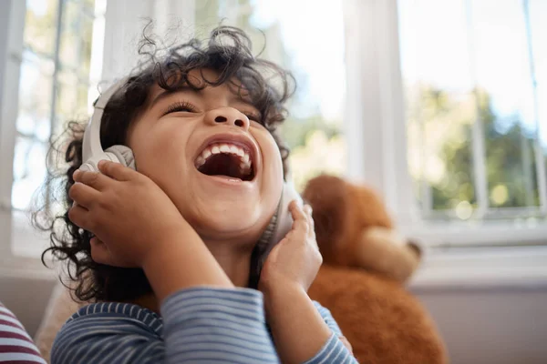 Dreading the day my world falls silent or into key. an adorable young boy using headphones in his bedroom at home