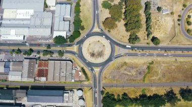 4k drone footage of vehicles driving around a traffic circle in Cape Town, South Africa.