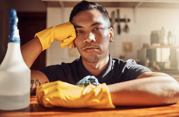 I should have called a cleaning service. Portrait of a young man looking unhappy after cleaning the kitchen at home