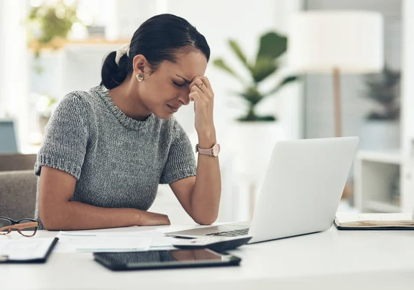 Trying hard to regain her focus. a young businesswoman looking stressed out while working in an office