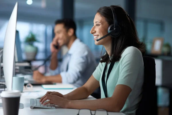 Morning has broken and the customer has spoken. a young woman using a headset and computer in a modern office