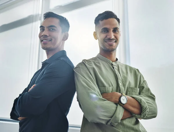 Hes got my back, and Ive got his. Cropped portrait of two handsome young businessmen standing back to back with their arms folded in their office